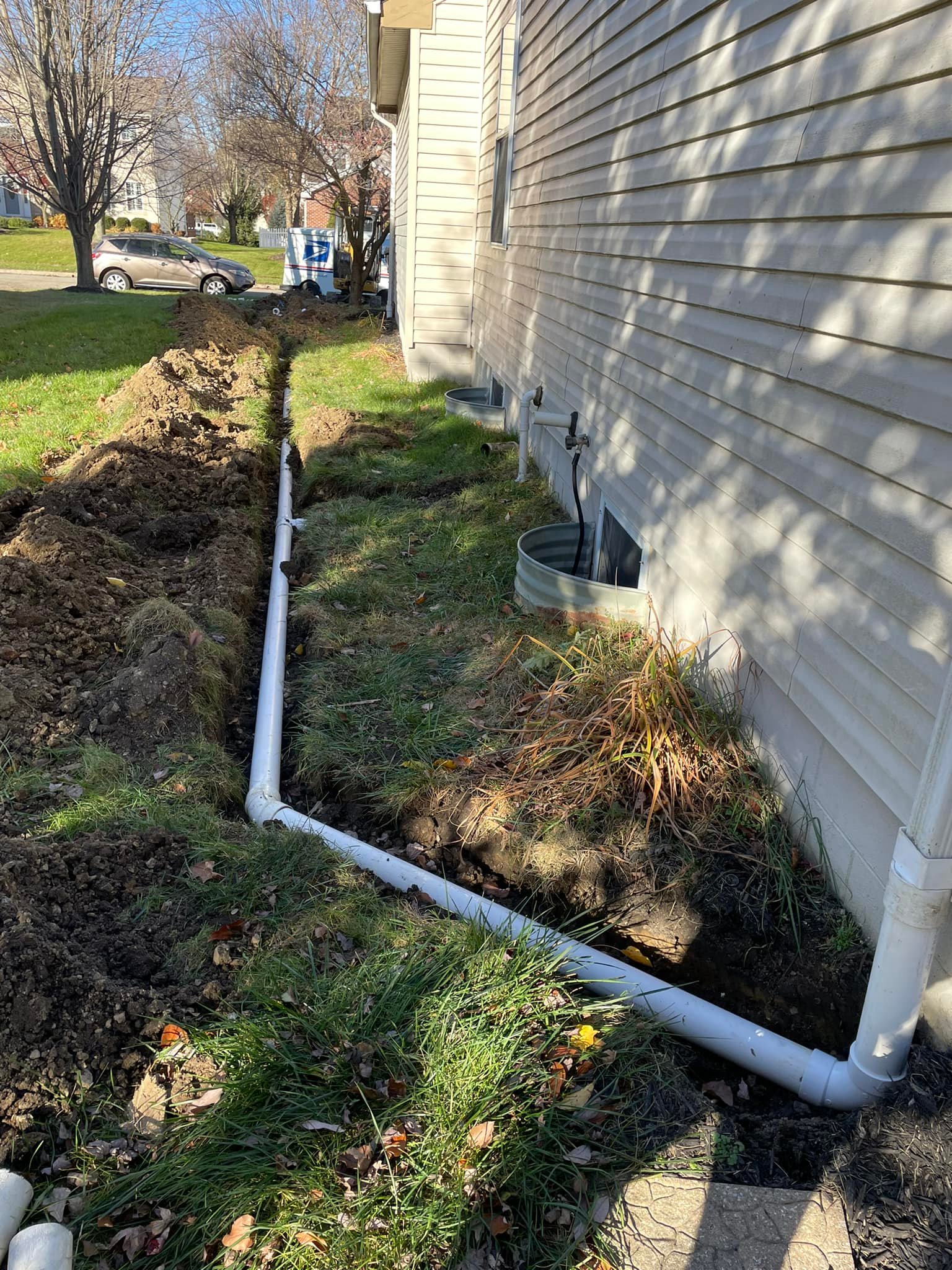 Titan Plumbing & Drains installing a new pipe to improve drainage and prevent plumbing issues near a home.