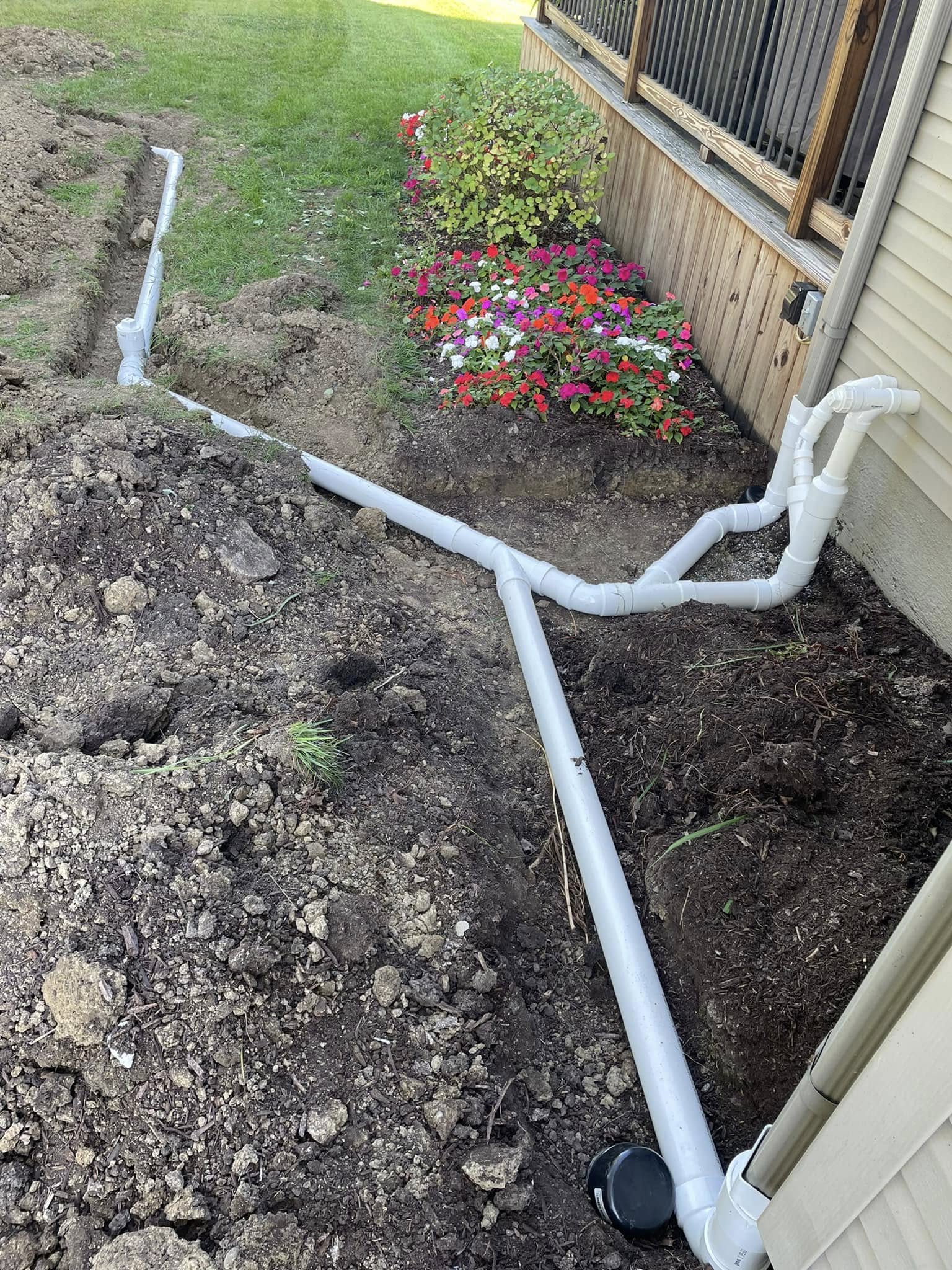 Titan Plumbing & Drains installs new sewer pipes for a home near a garden, replacing older plumbing underground.