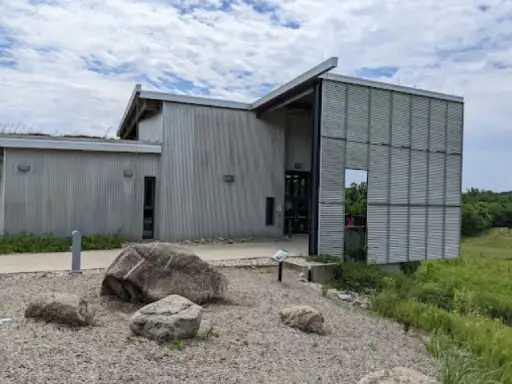 A Titan Plumbing & Drains building stands ready to help homes and businesses with plumbing needs. A sign nearby shows their services.