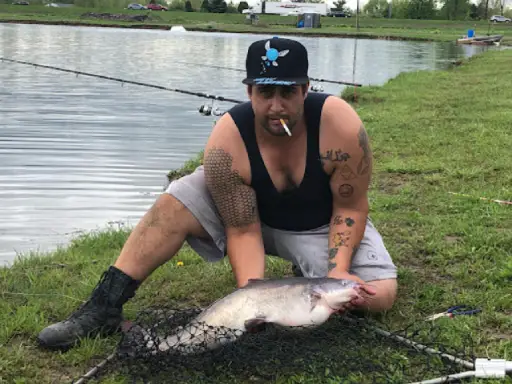 A Titan Plumbing & Drains plumber relaxes by fishing at a lake after a busy workday.