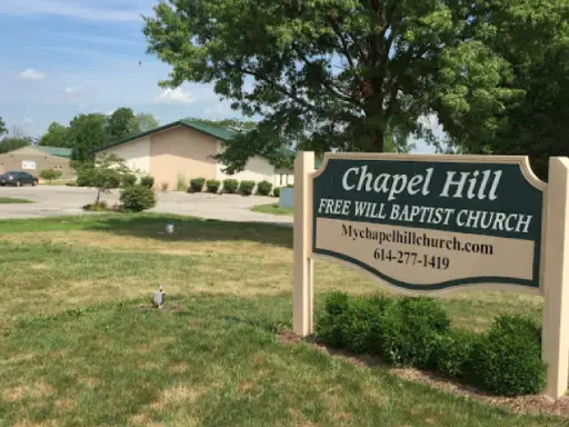 Chapel Hill Free Will Baptist Church and its sign show where the church is located, with outdoor space nearby.