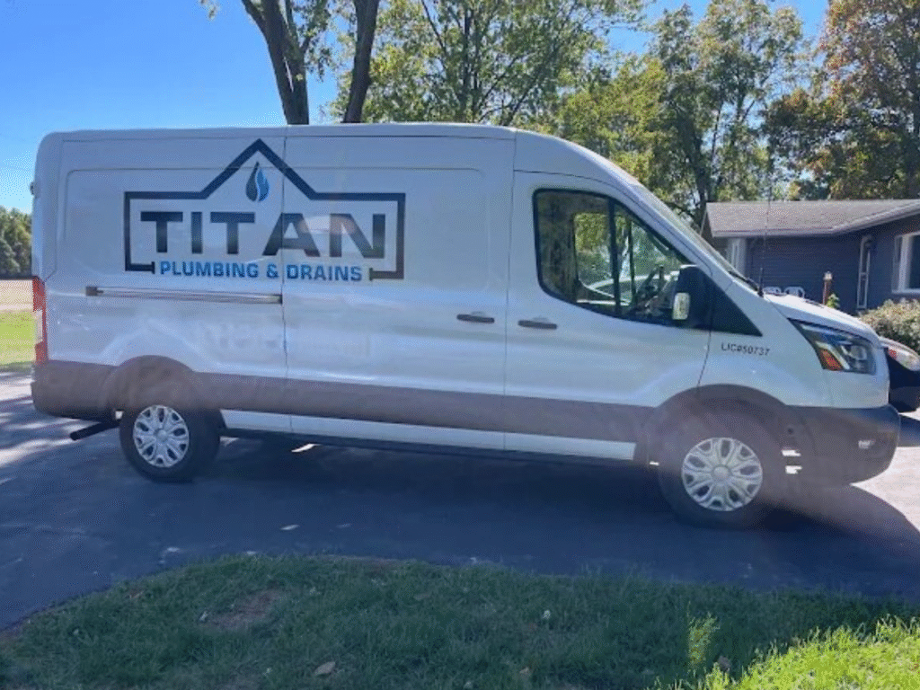 A Titan Plumbing & Drains van is parked outside a home, ready to help with plumbing or drain services.