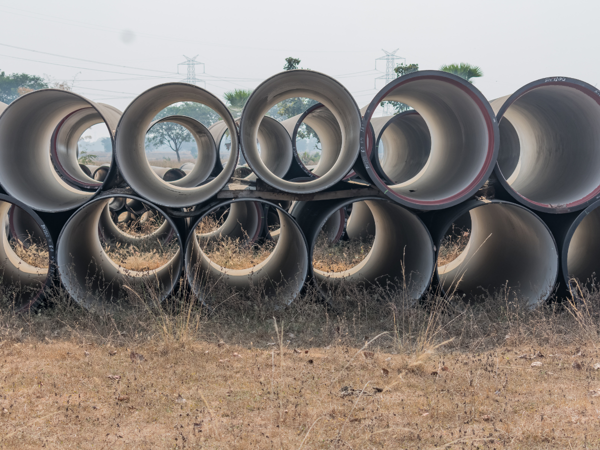 Concrete pipes ready for use in drainage projects by Titan Plumbing & Drains. Pipes show traditional material choice.