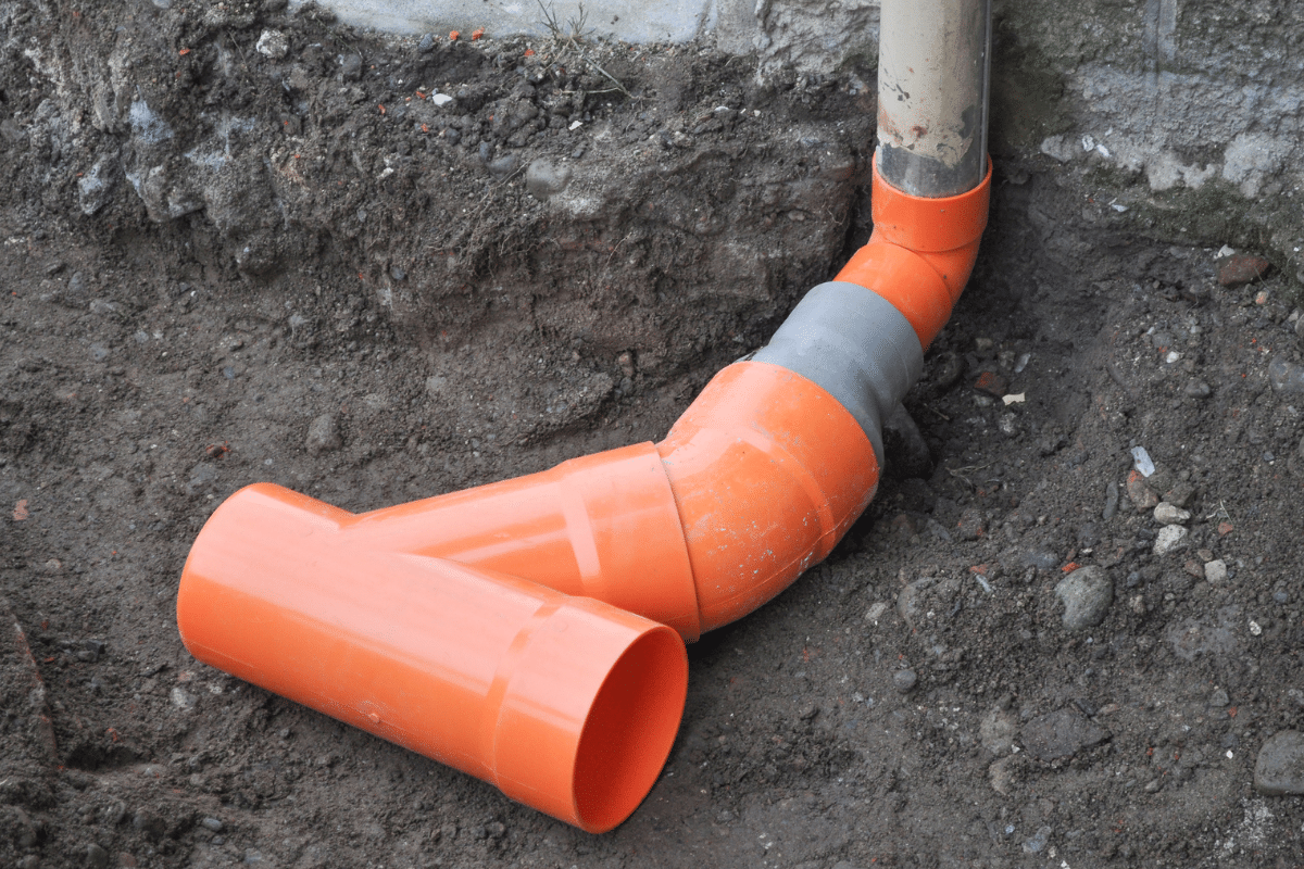 Titan Plumbing & Drains prepares PVC pipes in a trench for a new drainage system installation.